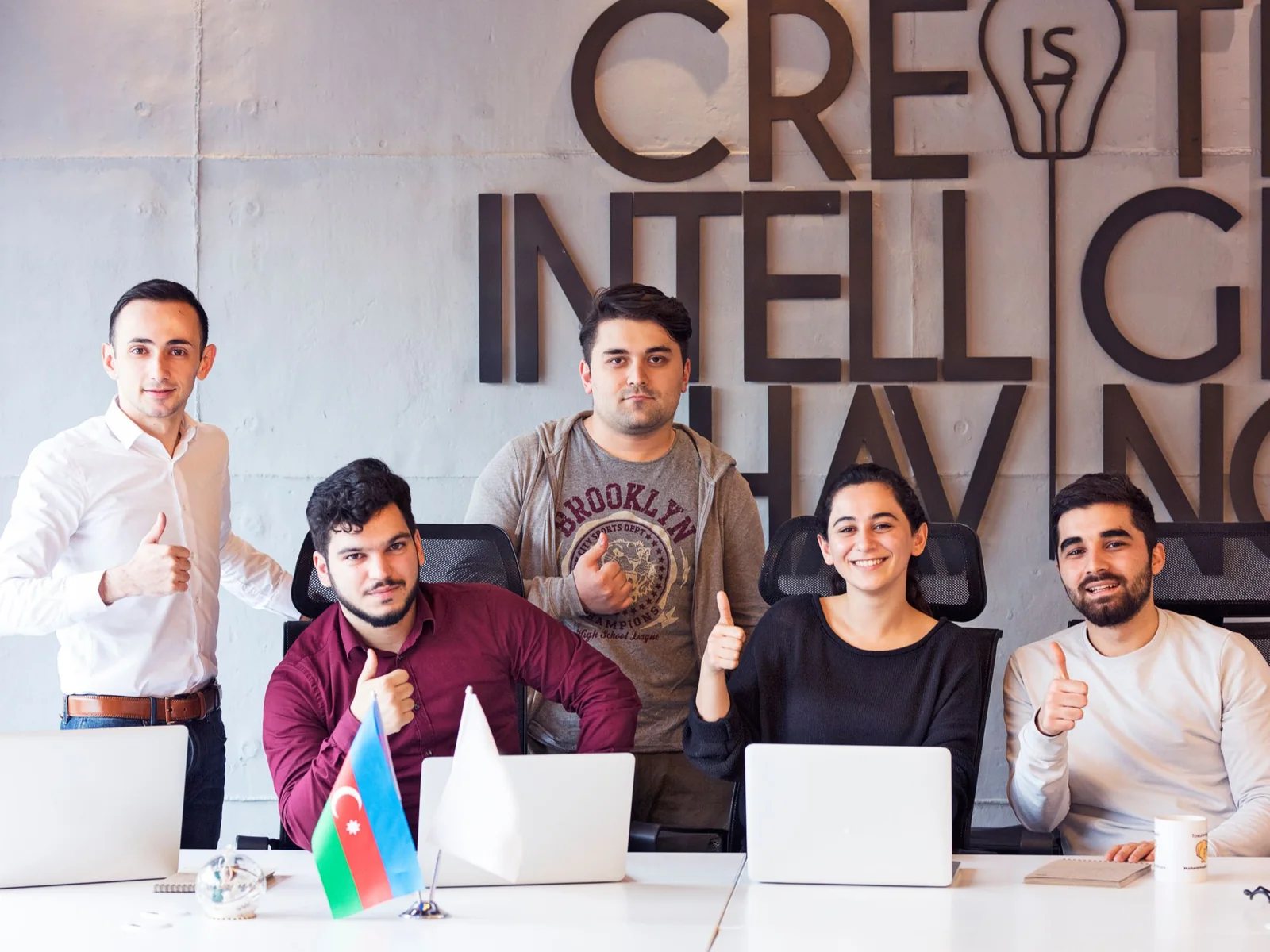 The Biznexa team giving a thumbs-up at their desks
